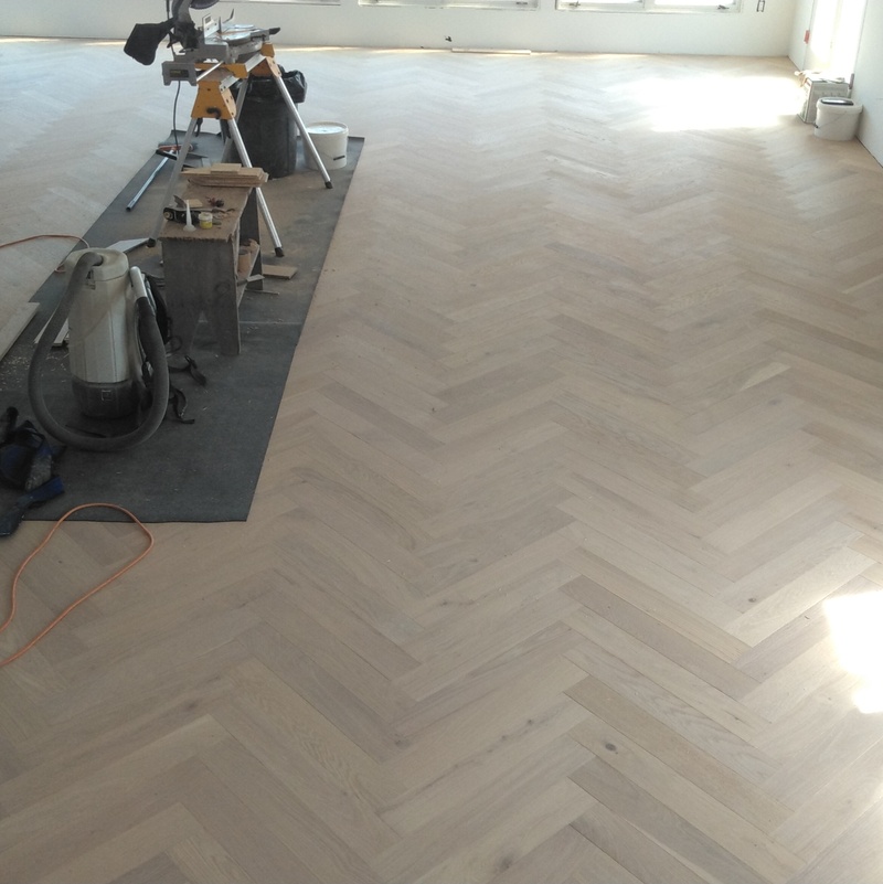Prefinished White Oak Herringbone pattern installed with a direct glue on concrete slab.